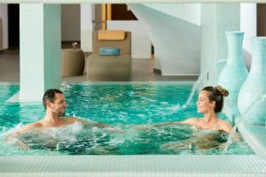 阿尔沃尔Longevity Health & Wellness Hotel - Adults Only的男女在游泳池游泳