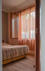 塔特夫Ana-Maria Bnb的一间卧室配有床和一个带粉红色窗帘的窗户。