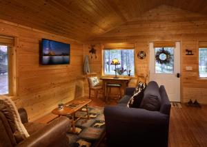 西格拉西尔Reclusive Moose Cabins的小屋内的客厅配有沙发和桌子