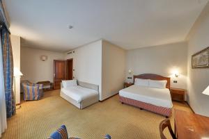 SandiglianoRelais Santo Stefano的酒店客房设有两张床和一张桌子。