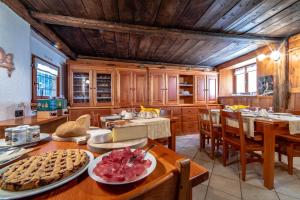 瓦尔格里森凯Antica casa di montagna Maison Bovard的厨房配有木制橱柜和一张带食物的桌子。