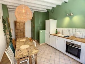 Saint-Alban-de-RocheLa Galerie的厨房配有桌椅和水槽