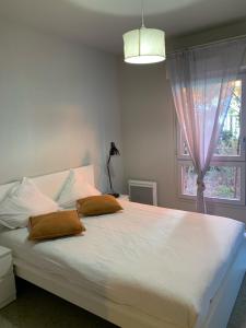 马赛马赛公寓式酒店的卧室配有一张大白色床和窗户