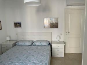 利帕里Villa Portinente的一间卧室配有一张带2个床头柜和2盏灯的床。