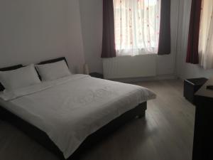 索瓦塔Casa Julius的一间卧室配有白色床单和红色窗帘