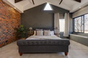比勒陀利亚HAVANA VILLA - Pretoria East Luxury Villa的卧室设有一张砖墙内的大床