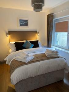 基拉尼Location Location - Gorgeous 3 Bed Apartment in Killarney的卧室配有一张带白色床单和枕头的大床。