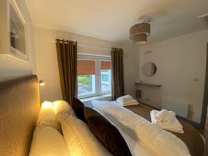 基拉尼Location Location - Gorgeous 3 Bed Apartment in Killarney的一间卧室设有一张大床和窗户