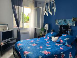 波城ELLO HAPPINESS HOME place to be in pau的一间蓝色卧室,配有一张床和电视