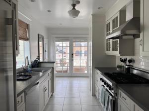 洛杉矶The Craftsman House in Venice Beach的厨房配有白色橱柜和炉灶烤箱。