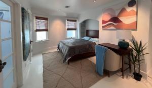 洛杉矶The Craftsman House in Venice Beach的卧室配有一张床,墙上挂有绘画作品
