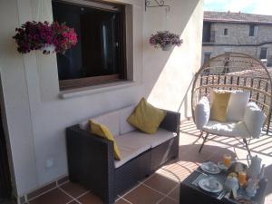 VillamielEscapada Romantica con Bañera y vistas al Castillo de Trevejo的阳台的门廊配有沙发和椅子