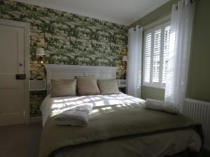 安赛德Kentwood Guest House的一间卧室配有一张带绿色和白色壁纸的床
