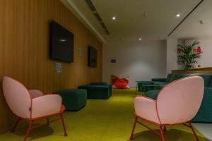 马略卡岛帕尔马The Boc Hostels - City的一间等候室,配有绿色椅子和粉红色椅子