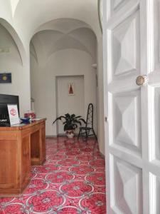 阿纳卡普里R&D Rest and Dream Capri的一间设有书桌的房间和一扇带地毯的门