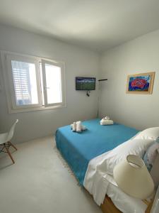 马里迪莫Dal Notaio, Appartamento Con Terrazza的白色卧室配有蓝色的床和椅子