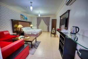 延布Al Fanar Al Alami 2- Haya'a malakeya的酒店客房,配有一张床和一张红色的沙发