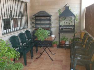巴埃萨Alojamiento Los Poetas的庭院配有桌椅和钢琴