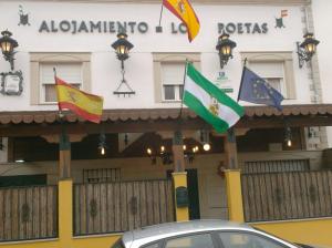 巴埃萨Alojamiento Los Poetas的前面有几个旗帜的建筑