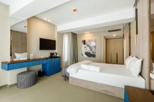 马马亚Onal Boutique Hotelier的酒店客房设有一张大床和一台电视。