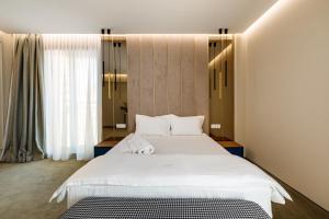 马马亚Onal Boutique Hotelier的卧室设有一张白色大床和一扇窗户。