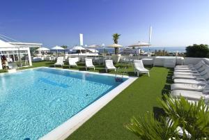 里乔内Hotel Mediterraneo的一个带躺椅的游泳池和海洋
