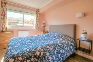 勒图凯-巴黎普拉日La Douce Vie的一间卧室配有一张带蓝色毯子的床和窗户。