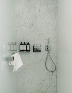 滨海圣帕莱Hôtel Hemen的一间设有白色大理石墙壁和淋浴的浴室