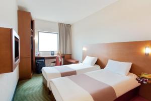 安曼ibis Amman的酒店客房设有两张床和电视。