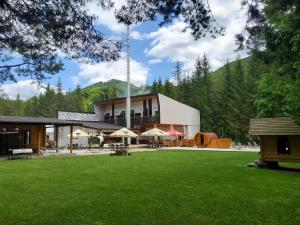 TrăisteniBOUTIQUE HOTEL DOFTANA NATURE EVENTS的前面有绿色草坪的大建筑