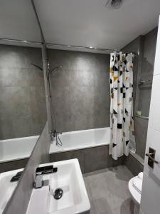 伊斯特布恩Pearl & Pebbles Eastbourne的浴室配有盥洗盆和浴缸。