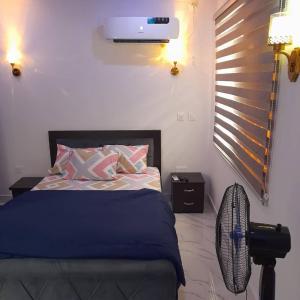 哈科特港Easyinn Shortlet Apartment的一间卧室配有一张床和风扇