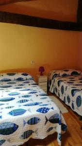 La CostanaLa casa azul del Pantano的一间卧室配有两张床和一张带台灯的桌子