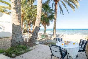 滨海罗克塔斯Bungalow Club Aguadulce 1的棕榈树和海洋海滩上的桌子