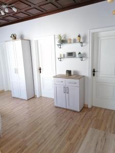 Schützen am GebirgeFerienhaus Savannah的厨房铺有木地板,配有白色橱柜。