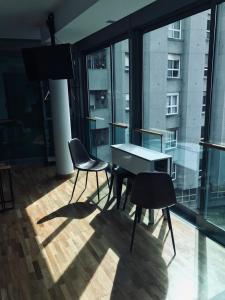 维戈Apartamento Rosario 2的配有大窗户的客房内的桌椅