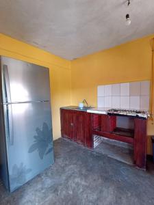 库奥特拉莫雷洛斯Casa De Descanso Cuautla Morelos的厨房配有冰箱和黄色墙壁