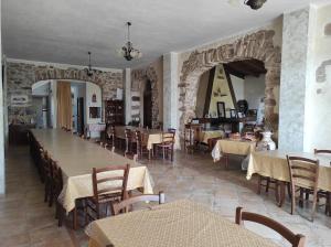 阿尔布斯Agriturismo Gragonti, Arbus Costa Verde的一间带桌椅和石墙的餐厅