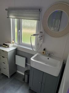 拉姆西The Cozy Cub的一间带水槽和镜子的浴室以及窗户。