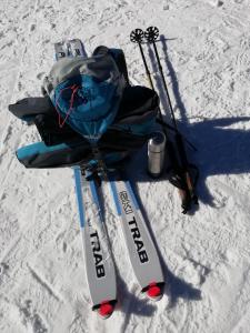 佩尔吉内瓦尔苏加纳CastelCharme b&b的雪地里一双滑雪板和背包及滑雪杆