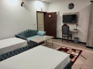 拉合尔Grand Swiss Hotel&Apartment Lahore的客厅配有沙发和桌子