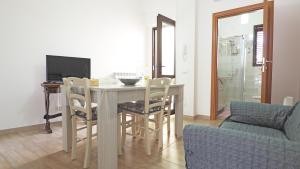 塔维亚诺Casa Manni Taviano-Salento的客厅配有桌椅和电视