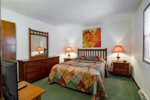 杜波依斯Crown Resorts at Wolf Run的一间卧室配有一张床、梳妆台和镜子