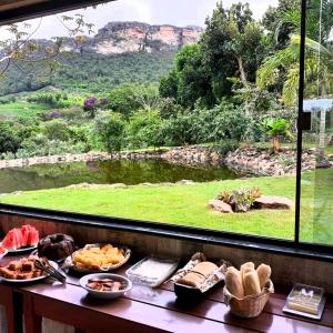 伊比科阿拉Pousada Raposa的一张带食物的桌子和一个美景窗户