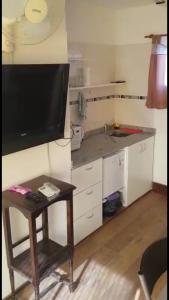 戈多伊克鲁斯Monoambientes Arizu的一个带桌子的小厨房和墙上的电视