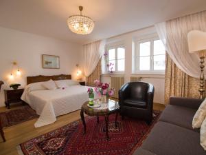 林茨Austria Classic Hotel Wolfinger - Hauptplatz的一间卧室配有一张床、一把椅子和一张桌子