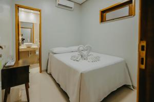维索萨-杜塞阿拉Pousada Vila Verde的卧室配有白色的床和镜子