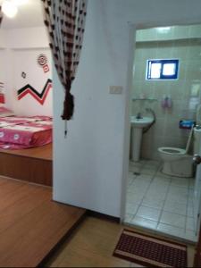 Lanyu兰屿我家の民宿的浴室设有床、卫生间和门。