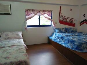Lanyu兰屿我家の民宿的一间卧室设有两张床和窗户。