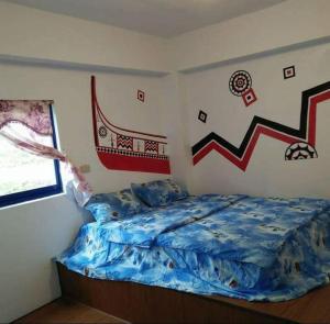 Lanyu兰屿我家の民宿的一间卧室配有一张带蓝色棉被的床